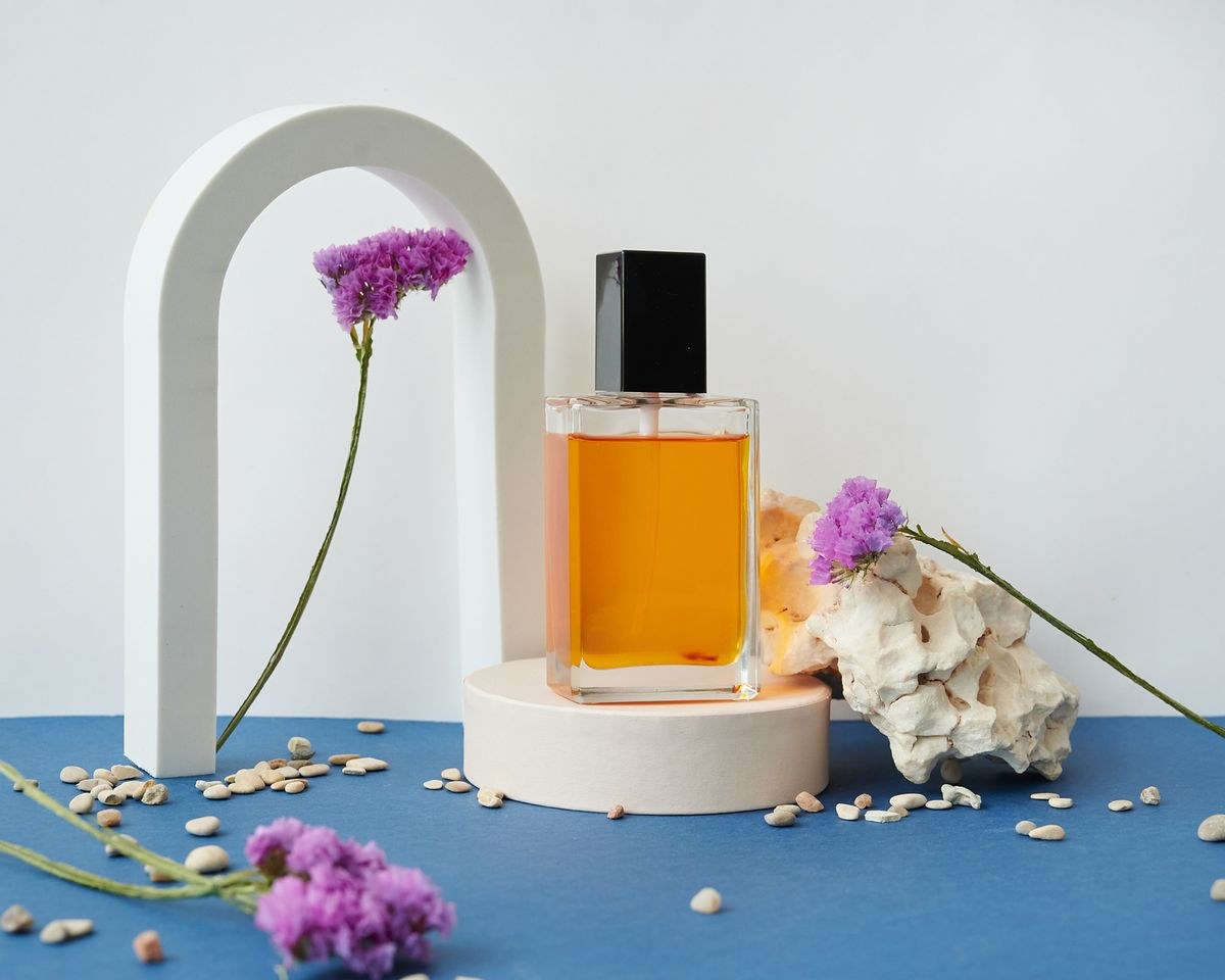 Ejemplo de fotografía de producto: frasco de perfume con flores y pedestal