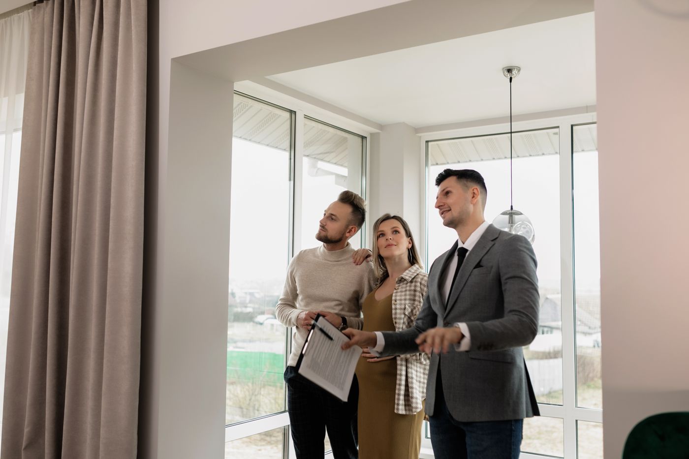 Agente inmobiliario enseñando un piso a una pareja
